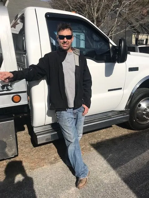 Derrick standing beside the Capital Towing truck