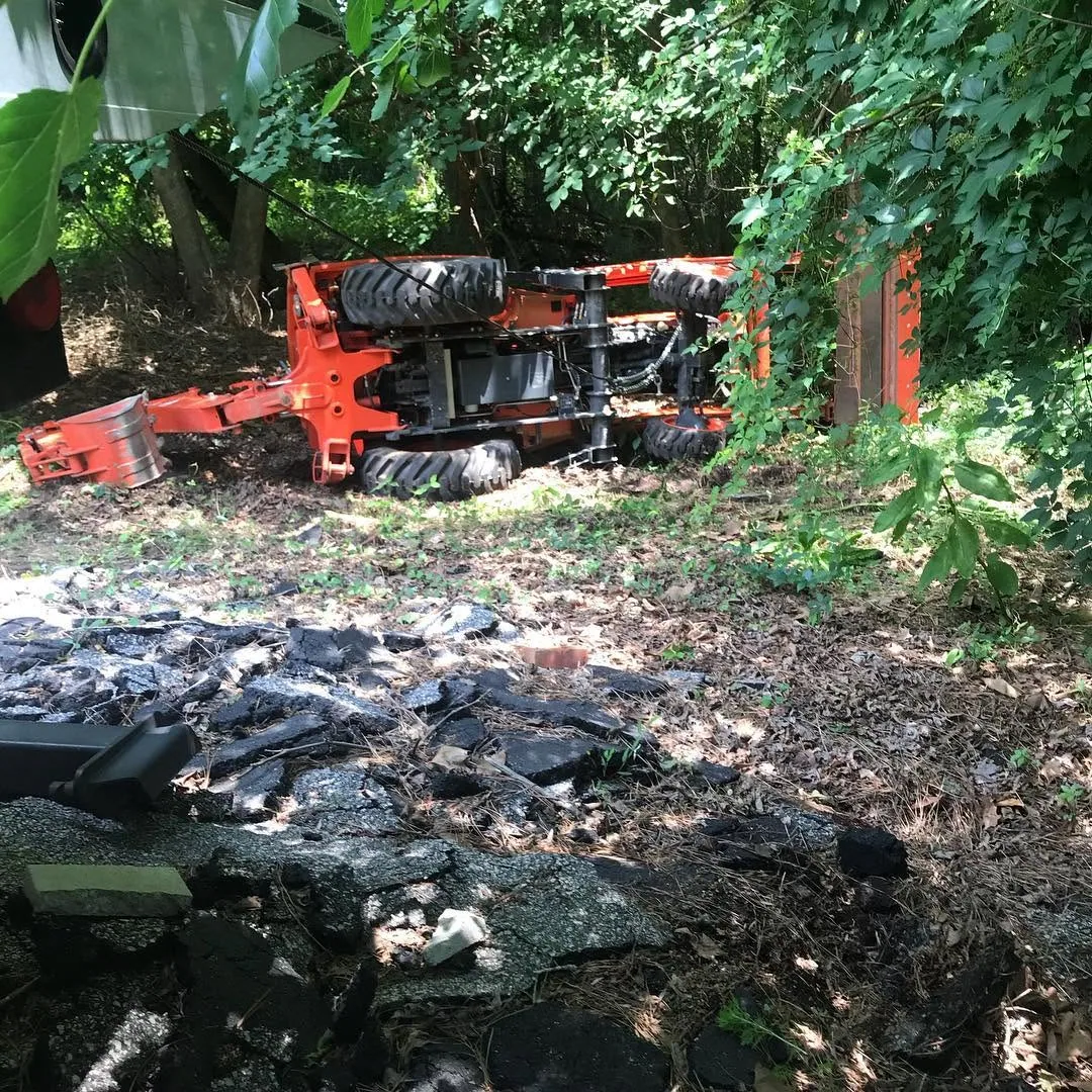 Overturned backhoe being recovered